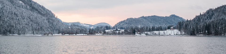 das bild zeigt den Hntersee im Winter, im Hintergrund beschneite Hügel